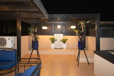 a room with two blue chairs and potted plants at Riad azzouina in Marrakech