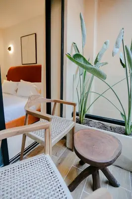 a room with two chairs and a bed and a plant at Premium Hospitality - Hivernage Marrakech in Marrakech