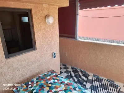 a room with a table and a window and a tiled floor at La maison de Hamza in Marrakech