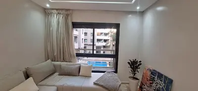 a living room with a couch and a window at Appartement Moderne Centre Gueliz Sunny Pool PS4 & Wi-Fi in Marrakech