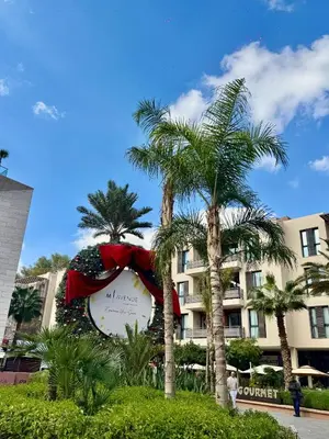 a large sign in front of a hotel with palm trees at Beldi Luxury apartment near M Avenue with Free Parking in Marrakech