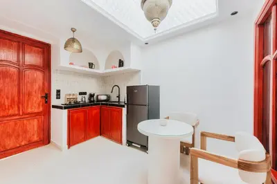 a kitchen with a small table and a refrigerator at Maison Joudia in Marrakech