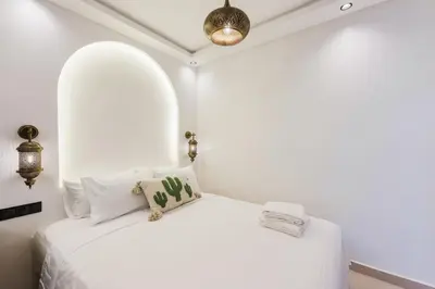 a white bedroom with a white bed with pillows at Maison Joudia in Marrakech