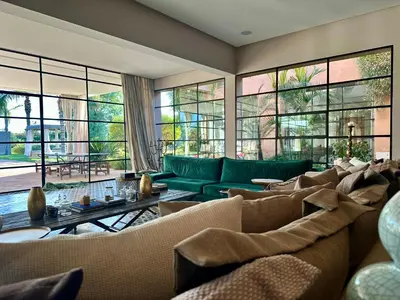 a living room with couches and tables and windows at Villa Serenity Marrakech in Châba