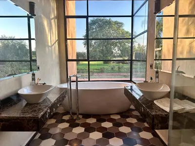 a bathroom with two sinks and a tub and windows at Villa Serenity Marrakech in Châba