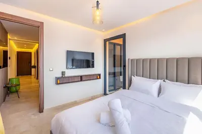 a bedroom with a white bed and a tv on the wall at Ultra Central Gueliz 1 bedroom in Marrakech