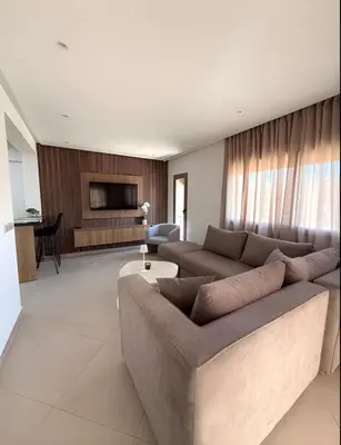 a living room with a large couch and a table at Central Gueliz Apartment Walk to Train Station in Marrakech