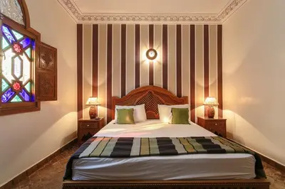 a bedroom with a bed and a stained glass window at Riad Safran - Private Cook & Indoor Pool Gem in Marrakech