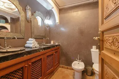 a bathroom with a toilet and a sink and a mirror at Riad Safran - Private Cook & Indoor Pool Gem in Marrakech
