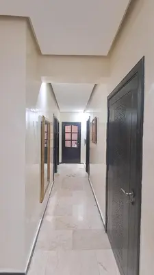 a hallway with a black door and a tile floor at Aux Majorelles-Gueliz in Marrakech