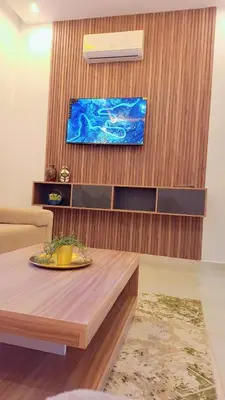 a living room with a table and a tv at Appartement Aéroport Suite Marrakech-M9 in Marrakech