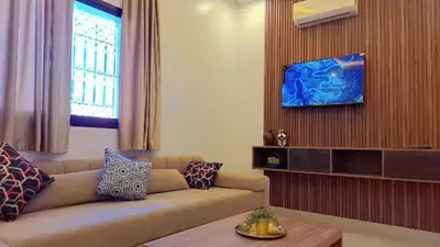 a living room with a couch and a tv at Appartement Aéroport Suite Marrakech-M9 in Marrakech