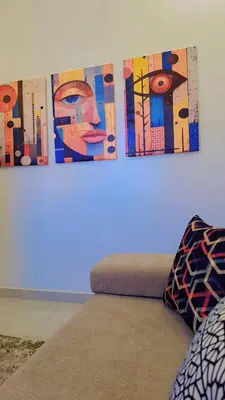two paintings hanging on a wall above a bed at Appartement Aéroport Palm Marrakech-M9 in Marrakech