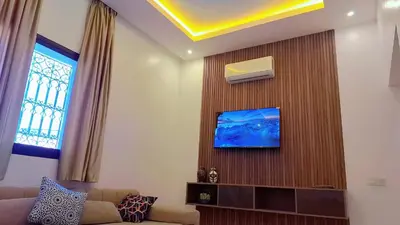 a living room with a couch and a tv on a wall at Appartement Aéroport Palm Marrakech-M9 in Marrakech
