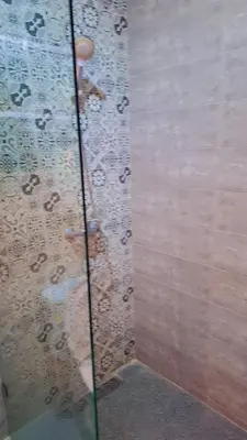 a shower with a glass door with raindrops on it at Appartement Aéroport Stay Marrakech-M9 in Marrakech