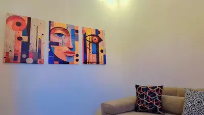 a painting of a woman on a wall next to a couch at Appartement Aéroport Sunset Marrakech in Marrakech