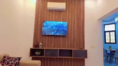 a living room with a tv on a wooden wall at Appartement Aéroport Sunset Marrakech in Marrakech