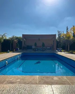 a swimming pool in front of a house at Charming Family Villa with Private Pool & Garden - Near Marrakech in Sraïri