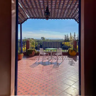 a patio with a table and chairs and a fence at Charming Family Villa with Private Pool & Garden - Near Marrakech in Sraïri