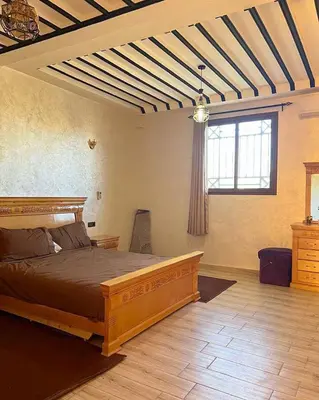 a bedroom with a wooden bed and a window at Charming Family Villa with Private Pool & Garden - Near Marrakech in Sraïri