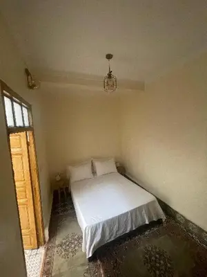 a bedroom with a bed in a room with a window at Dar darkoum in Marrakech
