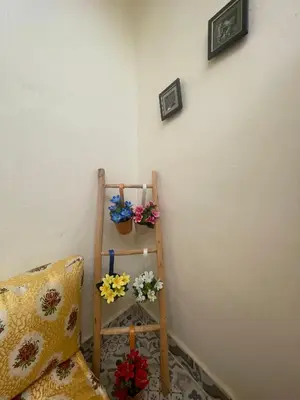 a corner of a room with a shelf with flowers at Dar darkoum in Marrakech