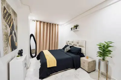 a white bedroom with a bed and a mirror at Terrace & Fast Wi-Fi - Stylish city center flat - Gueliz in Marrakech