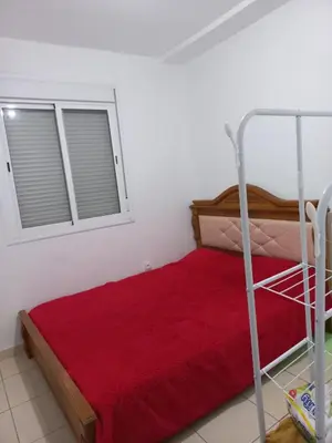 a bedroom with a red bed and a window at Marrakech in Marrakech
