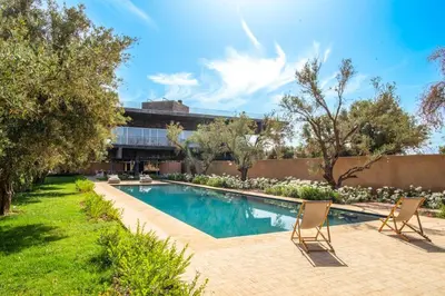 a swimming pool with two chairs in a yard at Villa Tacai in Graoua