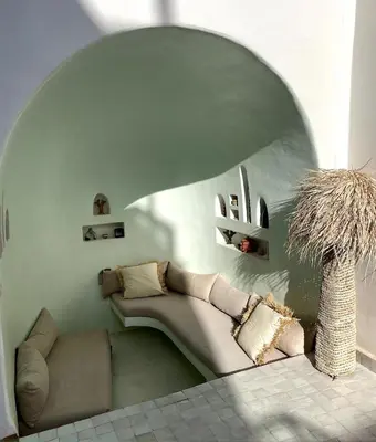 a living room with a couch and a vase at Riad Birdy, Charmant et privatif, Piscine, Rooftop, 6 suites, 2 salons, Wifi in Marrakech