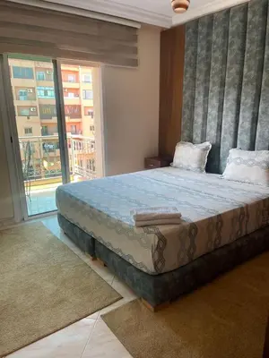 a bedroom with a large bed with a large window at Mobarak immo Appt 10 in Marrakech