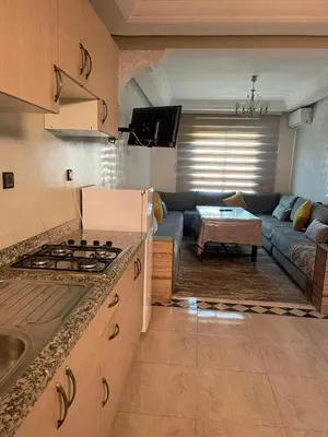 a kitchen and living room with a couch and a stove at Mobarak immo Appt 10 in Marrakech