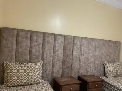 a bedroom with a large headboard and two tables at Mobarak immo Appt 10 in Marrakech
