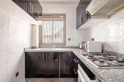 a white kitchen with a stove and a microwave at Moroccan Comfort & Charm - 10 min from Guéliz in Marrakech