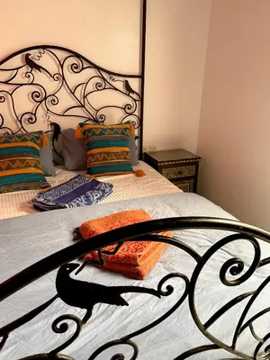 a bedroom with a bed with a wrought iron headboard at Riad Serenity Palmeraie in Marrakech