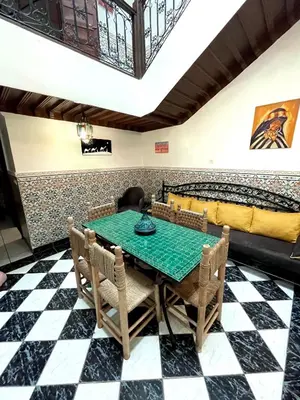 a dining room with a green table and chairs at Riad Serenity Palmeraie in Marrakech