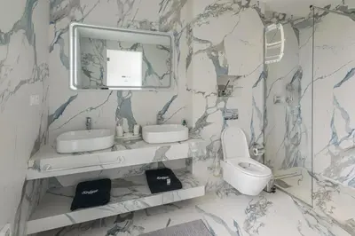 a bathroom with a sink and a toilet and a mirror at Villa Sofya - Roche Bobois Design & HD Wifi in Marrakech