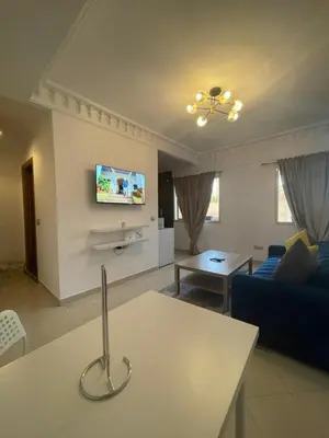 a living room with a blue couch and a tv at Studio Stay Marrakech in Marrakech