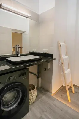 a bathroom with a sink and a washing machine at 2BR Art Deco Loft - Central Gueliz Marrakech in Marrakech