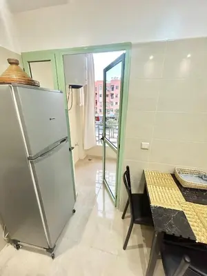 a kitchen with a refrigerator and a table and a window at Cozy Apartment 10 minutes from Gueliz and Medina in Marrakech