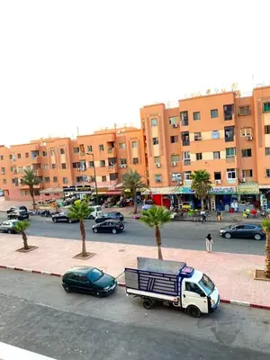 a street with cars parked in a parking lot with buildings at Cozy Apartment 10 minutes from Gueliz and Medina in Marrakech