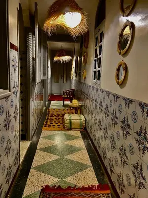 a hallway with a tile floor and a table in a room at Dar Koutobia Stars in Marrakech