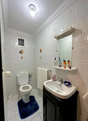 a white bathroom with a toilet and a sink at Charming apartment with a traditional style in Marrakech