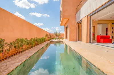 an infinity pool in the backyard of a house at Luxury 5-Suite Villa with private pool in GOLF Amlkis ,free Airport transport service in Marrakech