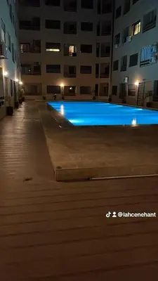a swimming pool in the middle of a building at night at Studio confort à Hivernage Piscine, parking & toutes commodités in Marrakech