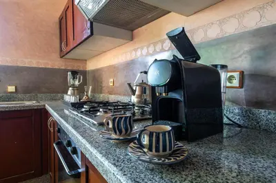 a kitchen with a stove and a coffee maker at Résidence Qodwa in Marrakech