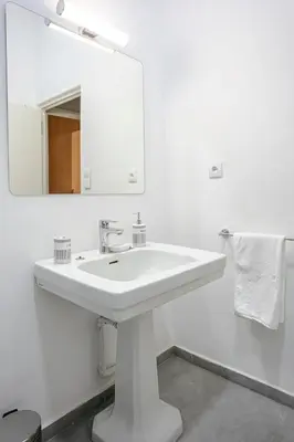 a white bathroom with a sink and a mirror at Art Deco Loft 1BR Central Guéliz Marrakech in Marrakech