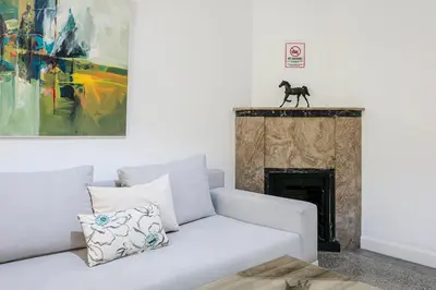 a living room with a couch and a horse statue on a fireplace at Art Deco Loft 1BR Central Guéliz Marrakech in Marrakech