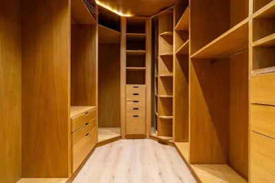 a walk in closet with wooden cabinets and shelves at Zen Villa Private Parking in El Rhechat