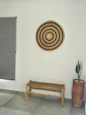 a wooden bench against a white wall with a rattanarmaarmaarmaarmaarma at Villa LAM atlas view in Tameslouht